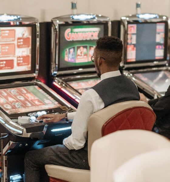 A group of people playing slot machines Description automatically generated