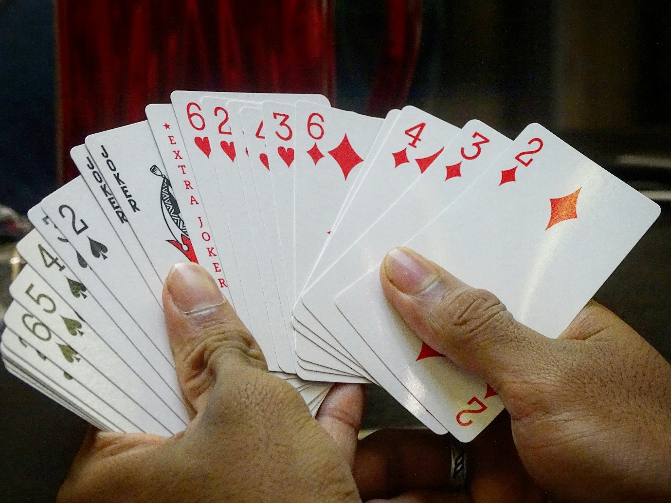 A hand holding a deck of cards

Description automatically generated